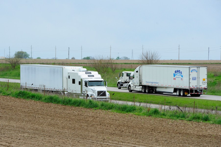 Semi-trucks and their different semi-truck trailers driving down the road.