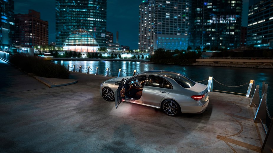 Silver 2023 Mercedes-Benz E-Class midsize luxury car parked near a river, highlighting its release date and price