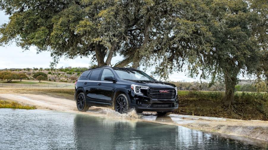 A black 2022 GMC Terrain driving. Is the SLE or SLT trim better?