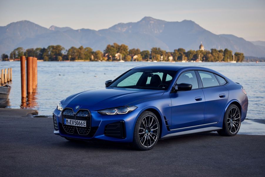 A blue BMW i4 M50 parked on a beach as the tide rises near its rear wheels