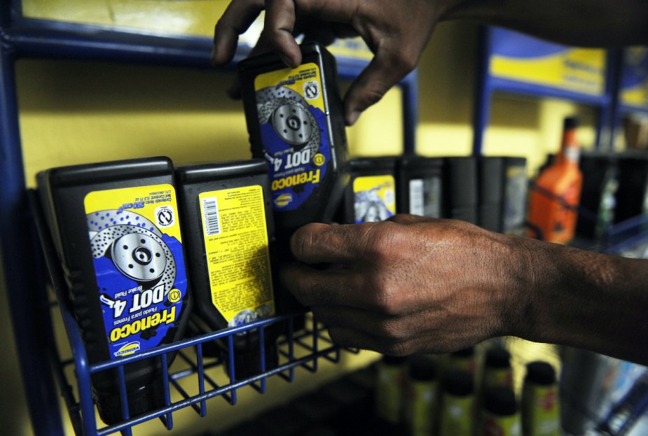 A worker picks a bottle of brake fluid at a distribution center.