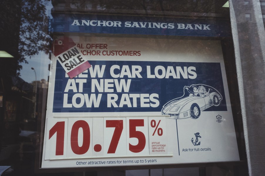 A sign in the window of the Anchor Savings Bank advertising car loan rates.