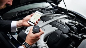 Detail of a man with a Streetwise GPS Tracker photographed with an Aston Martin Vanquish Volante.