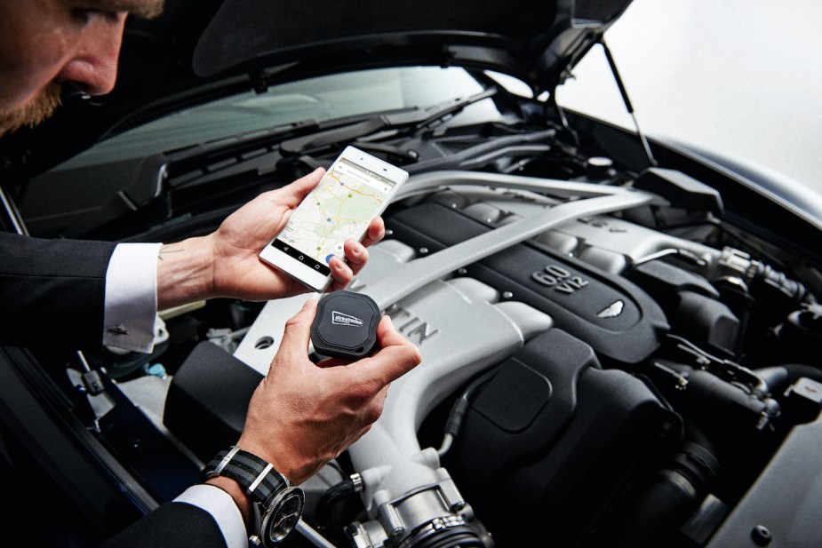 Detail of a man with a  Streetwise GPS Tracker photographed with an Aston Martin Vanquish Volante.