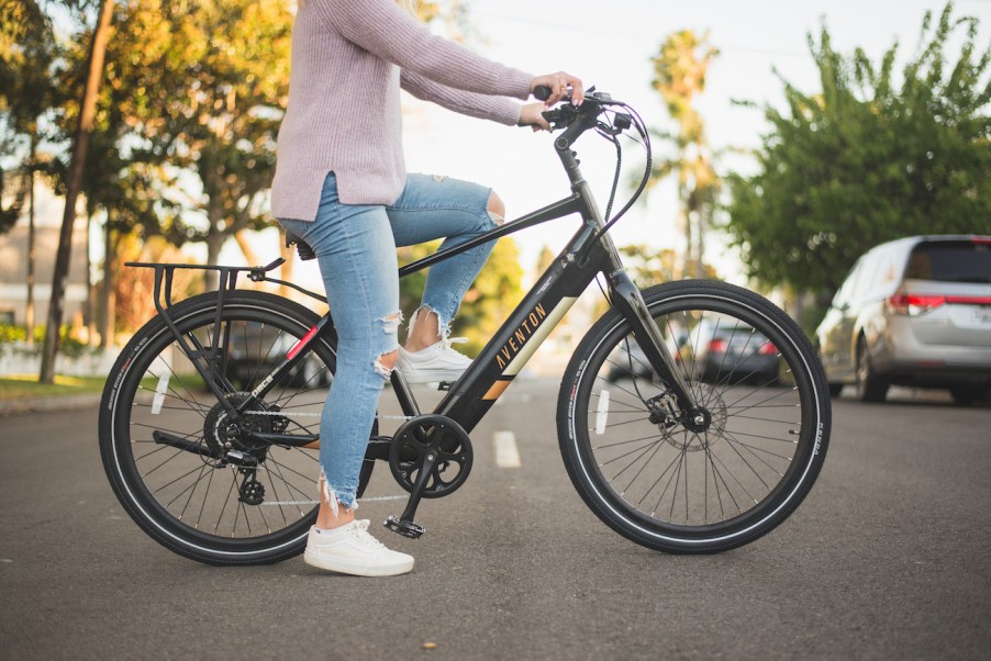 A rider sits on an Aventon Pace 500 in the middle of the street.