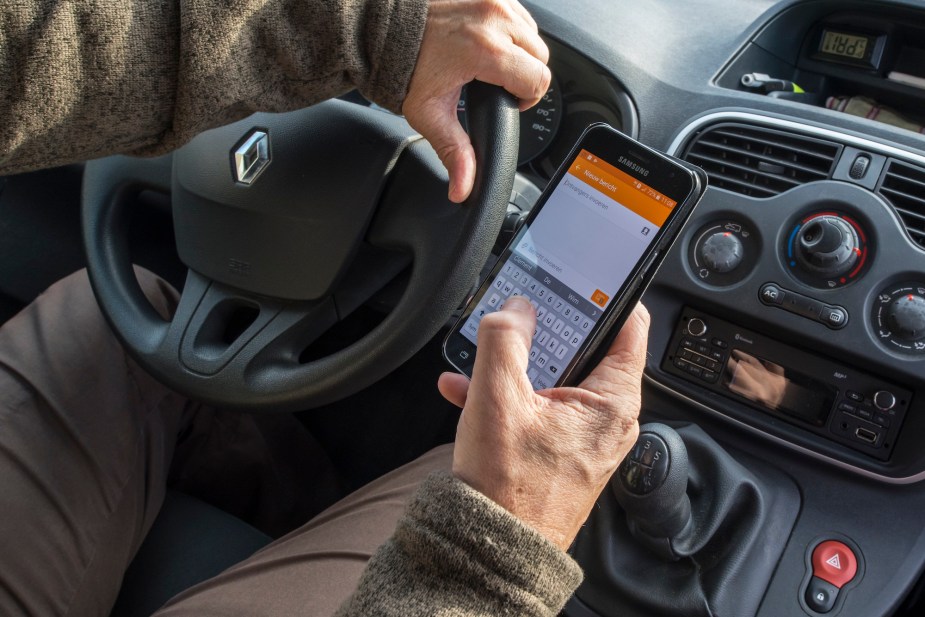 A person texting while driving. 