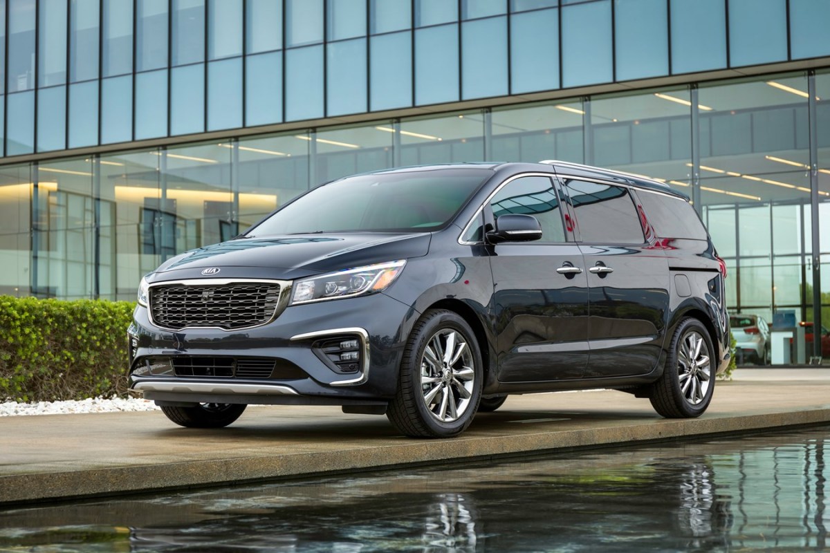 A black Kia Sedona near a water feature