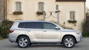 2008-2010 generation of the Toyota Highlander midsize SUV side shot next to a villa