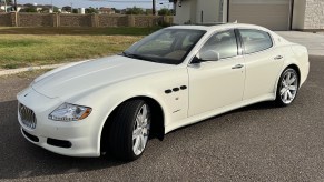 A used white 2010 Maserati Quattroporte S on a city street