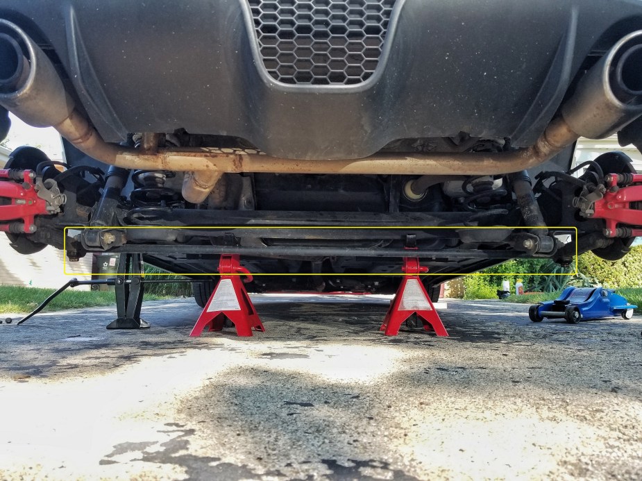 The rear torsion bar suspension on a 2013 Fiat 500 Abarth with the bar highlighted in yellow