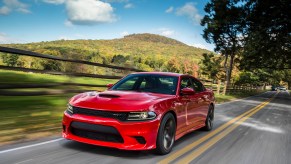 A 2015 Dodge Charger SRT Hellcat blasts down a rural road.