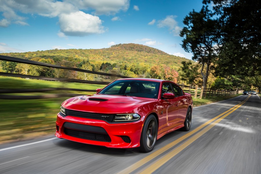 A 2015 Dodge Charger SRT Hellcat blasts down a rural road.