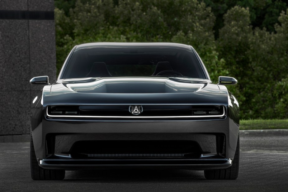 Promo photo of the front of a Dodge Charger Daytona SRT EV concept car, trees visible in the background.