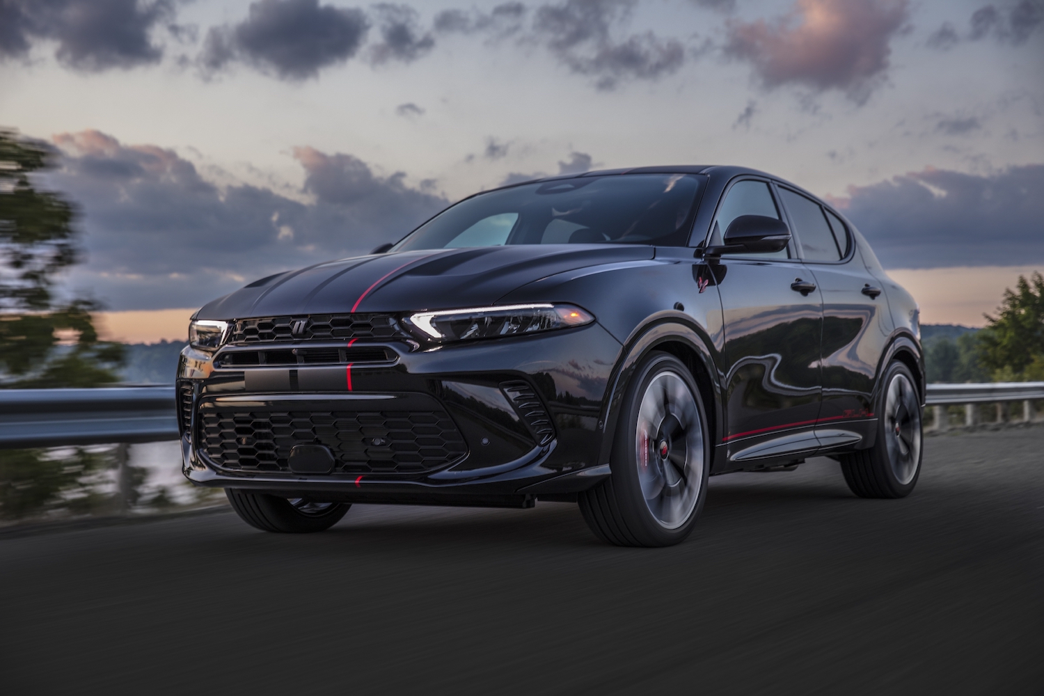 The Dodge Hornet GLH concept muscle CUV driving down a rural road at sunset.