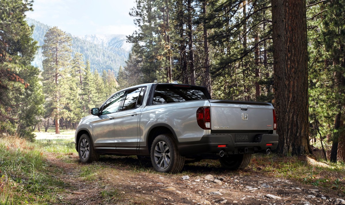 A silver 2022 Honda Ridgeline midsize pickup truck parked in the woods