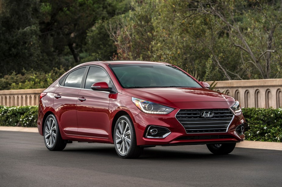 2022 Hyundai Accent in red parked in front of a fence.