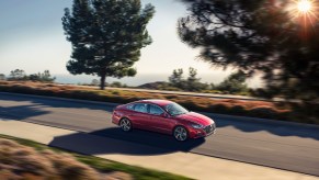 A red 2022 Hyundai Sonata Hybrid car driving