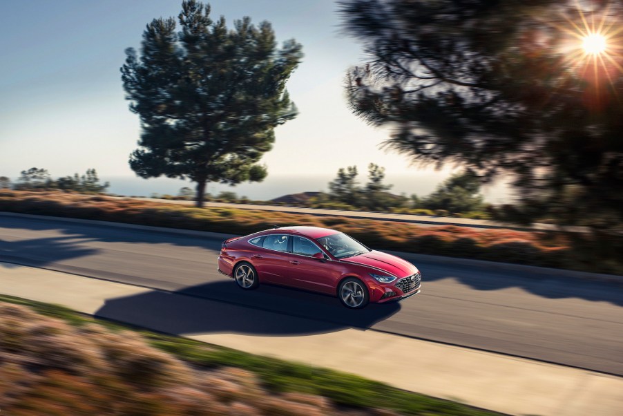 A red 2022 Hyundai Sonata Hybrid car driving