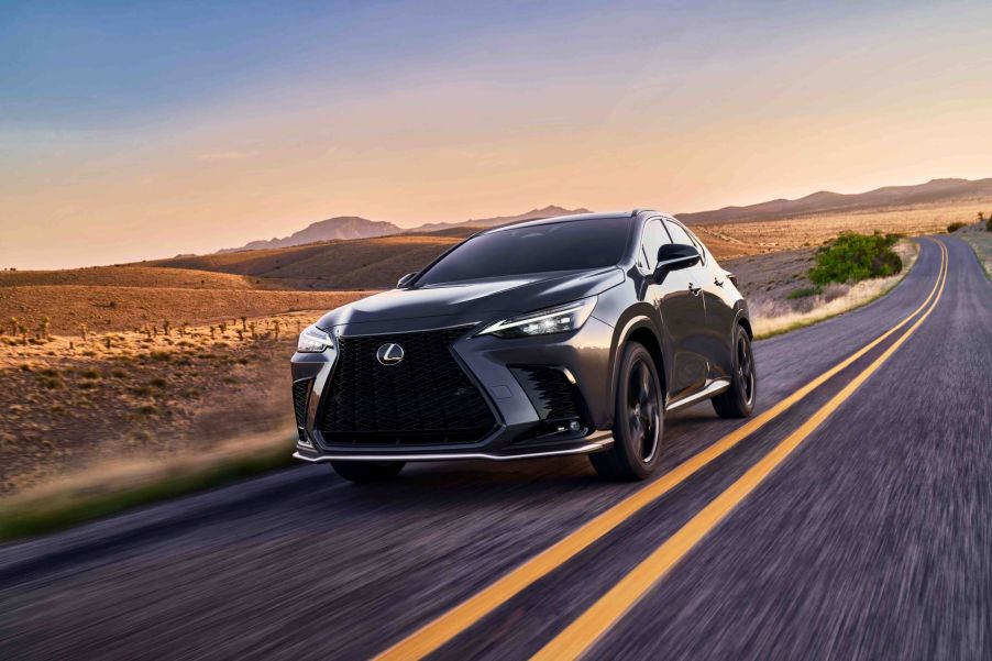 A dark gray 2022 Lexus NX 350 F Sport luxury compact SUV speeding down a barren country highway