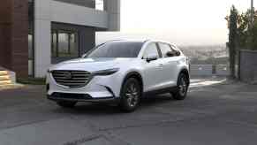 A white 2022 Mazda CX-9 next to a house.