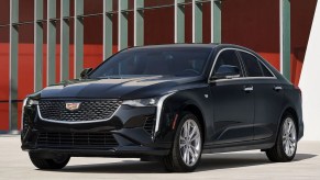 A black 2023 Cadillac CT4 Luxury 350T in front of a red-and-white building