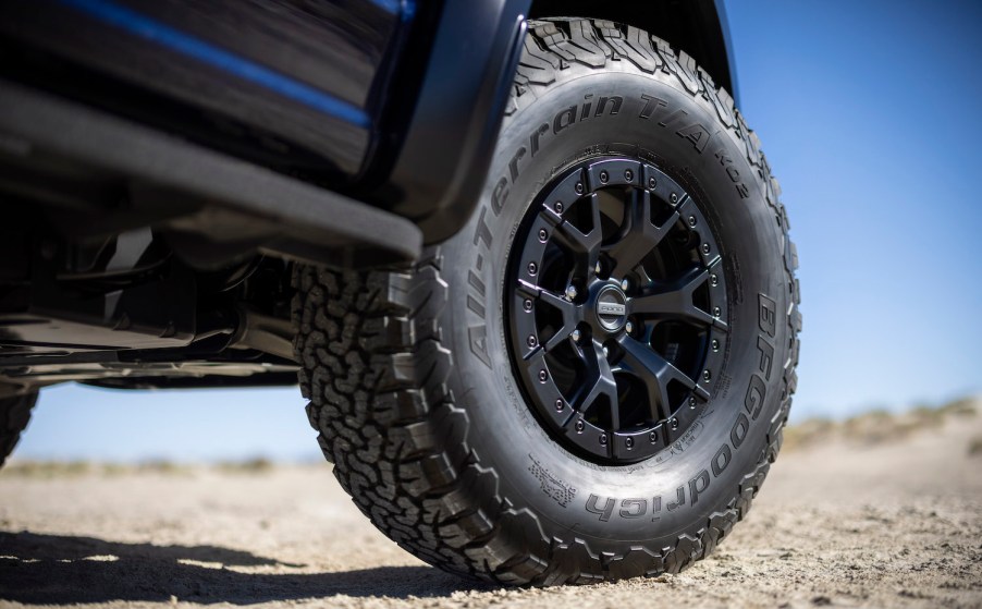 Closeup of a Ford F-150 tire parked in the desert.