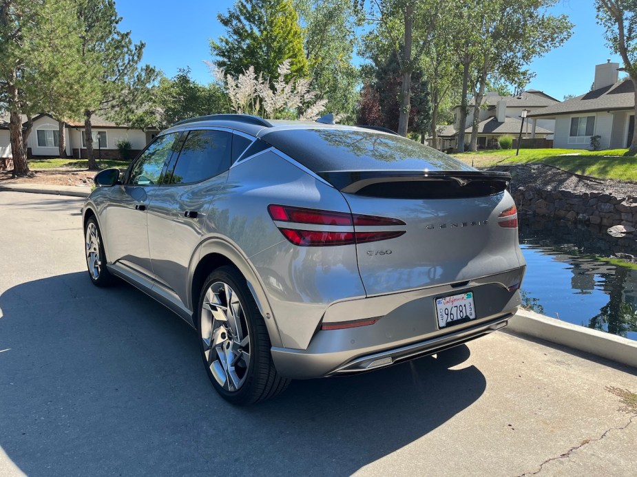 A rear view of the 2023 Genesis GV60 next to a pond.