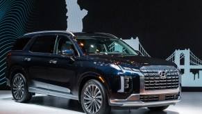 A dark colored 2023 Hyundai Palisade parked indoors.