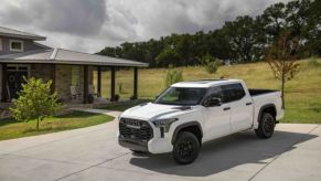 A 2023 Toyota Tundra TRD Pro full-size pickup truck in Super White parked outside a country rural home