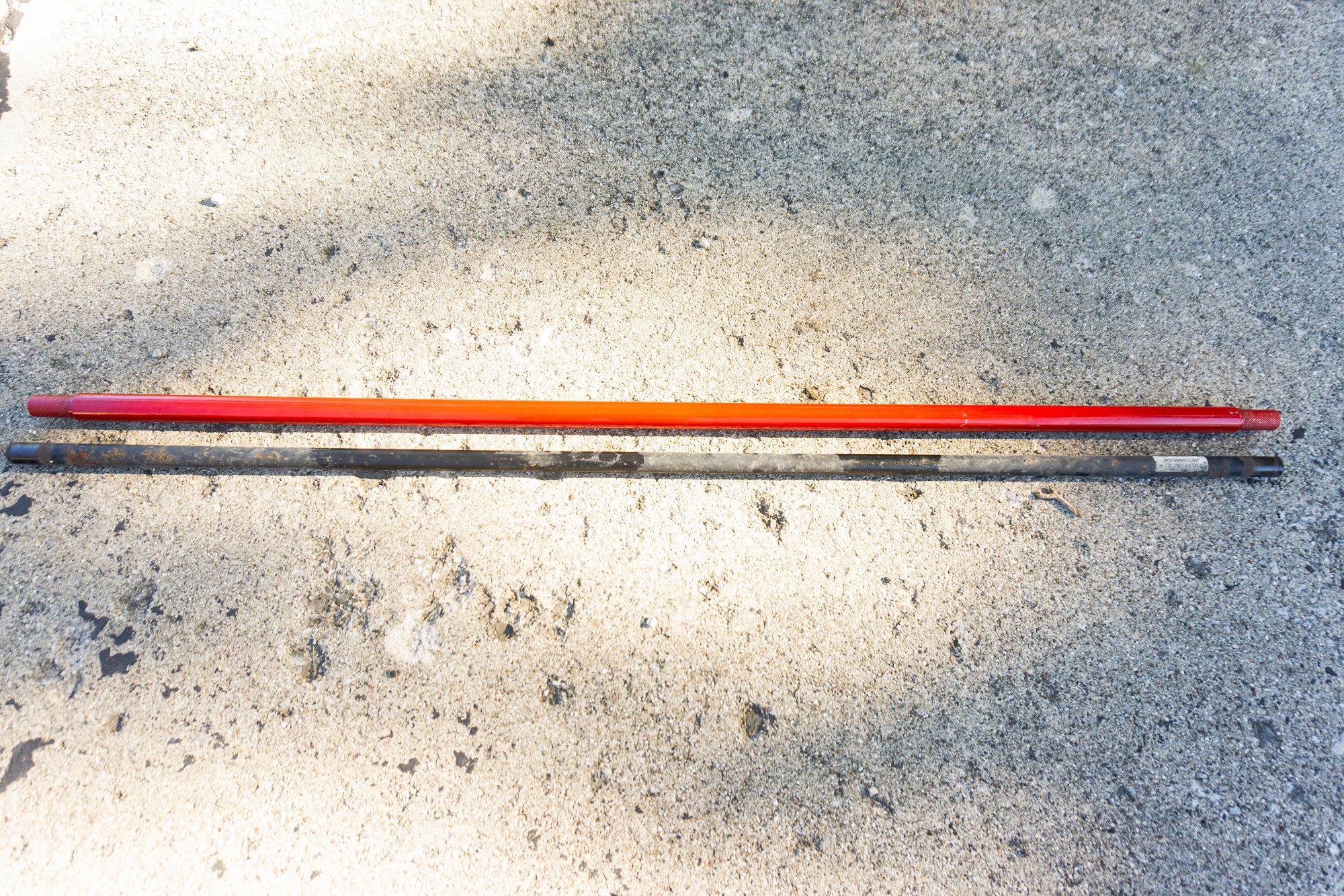 A red aftermarket Neu-f rear torsion bar on top of a black stock 2013 Fiat 500 Abarth one