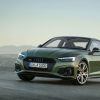 A green Audi A5 Coupe luxury car model parked on a asphalt in a terrain of hills covered in fog