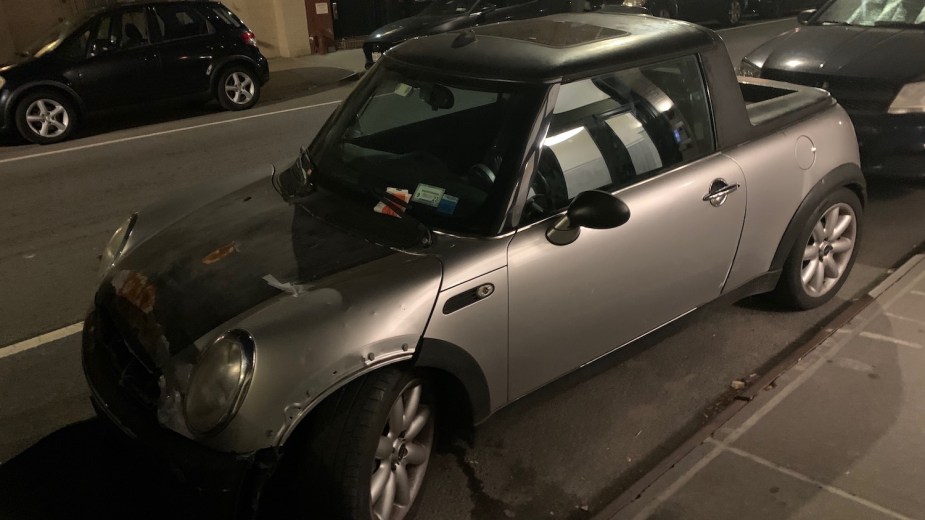 Silver Mini Cooper custom pickup truck parked on a city street.