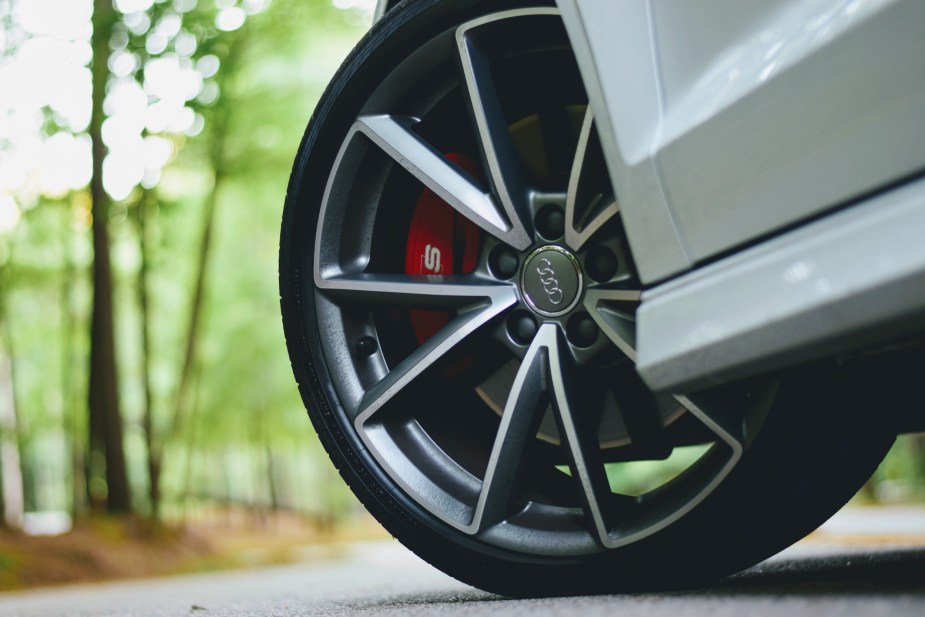 A close up photo of a car tire with red brake calipers