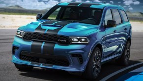 A blue Dodge Durango SRT Hellcat is driving on a track.