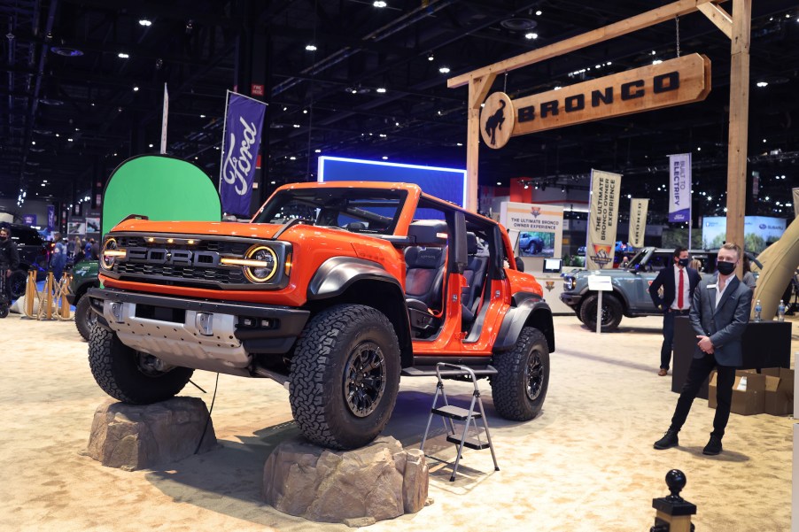 Potentially an orange Ford Bronco Raptor set indoors in an imitated outdoor scene.