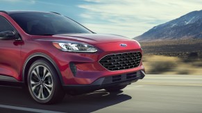 A red 2022 Ford Escape PHEV small plug-in hybrid SUV is driving on the road.