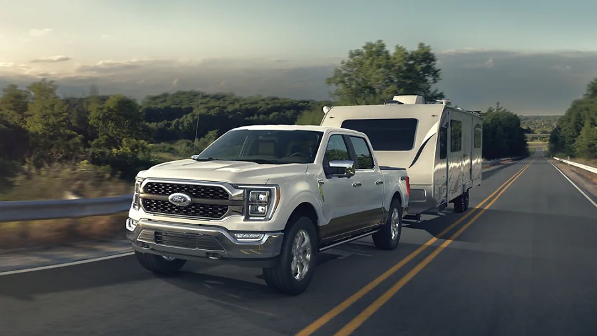 White Ford F-150 Towing a Travel Trailer on a highway