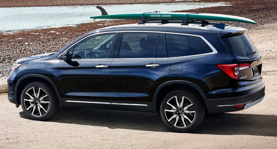 A blue Honda Pilot midsize SUV is parked outdoors. 