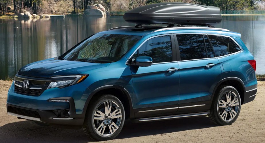 A blue Honda Pilot midsize SUV is parked outdoors. 