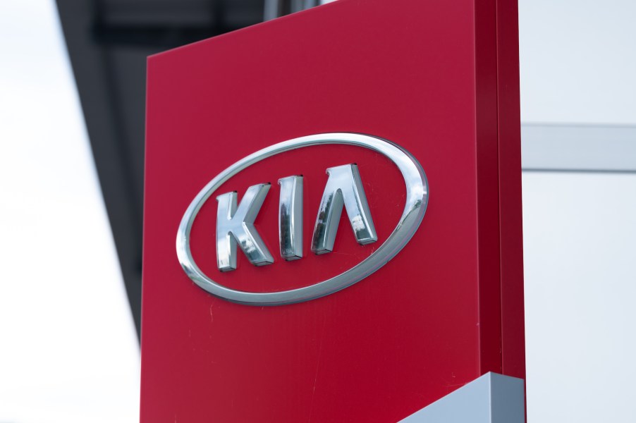 A red Kia sign with the logo. Some of the cars at the dealer could qualify for a free engine replacement.