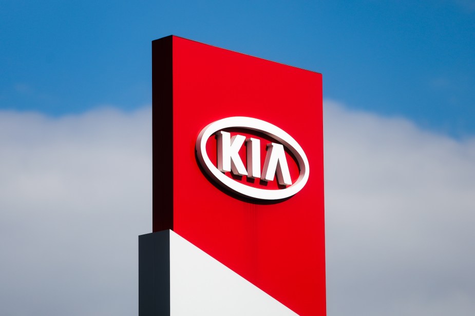 A Kia logo on a red sign.