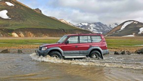 An 80 Series Toyota Land Cruiser fords a river.