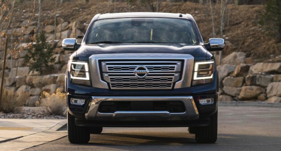 A blue Nissan Titan full-size pickup truck is parked. 