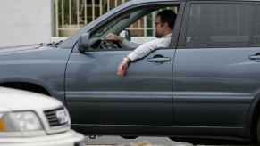 Person with their window down that could be experiencing that weird sound that happens when your car window is open.