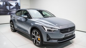 A silver Polestar 2 in a white room.