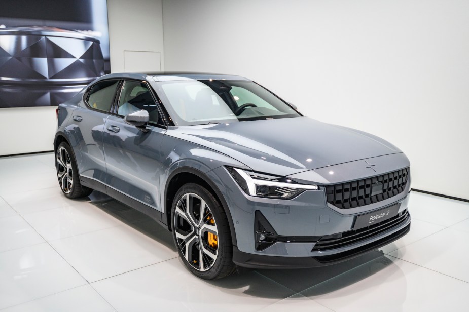 A silver Polestar 2 in a white room. 