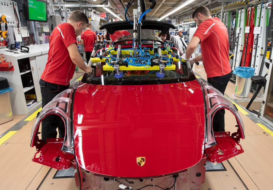 Employees of Porsche AG mount the windshield on a Porsche 911