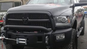 A lifted 2013 Ram 1500 sits in a parking lot.