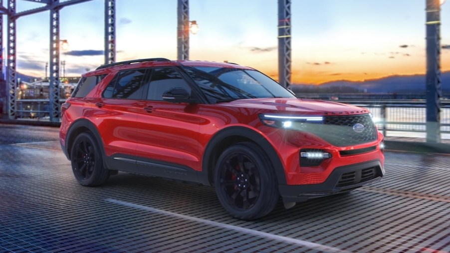 Rapid Red 2023 Ford Explorer midsize SUV driving over a bridge