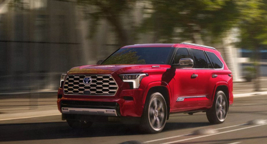 A red 2023 Toyota Sequoia is driving on the road. 